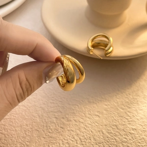 Macro detail of high-quality double-layered C-shape gold earrings with a polished finish