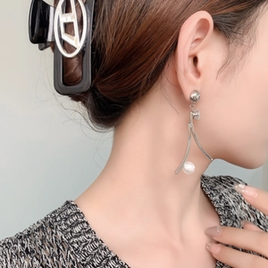 Orecchini geometrici retrò con zirconi, perle bianche e finitura argento indossati da modella