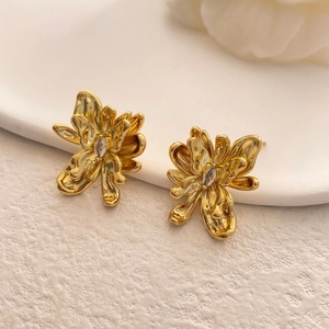 Macro shot of gold plated flower stud earrings with sparkling marquise cut zircon stones