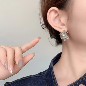 Exquisite 18K gold plated flower stud earrings with zircon stones on a model's ear