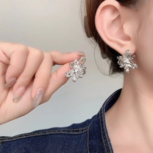 Macro detail of elegant silver flower stud earrings with sparkling cubic zirconia center