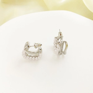 Elegant silver C-shaped multi-layer earrings with zircon and pearls on white stand