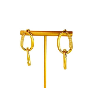 Irregular gold oval earrings with textured woven circles displayed on a metal T-stand