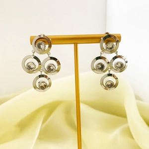 Detail of silver geometric earrings with sparkling zircon stones on a T-bar display stand
