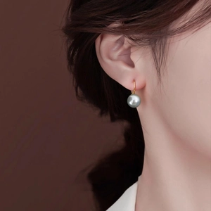 Elegant 10mm grey pearl drop earrings with minimalist gold hooks on a female model