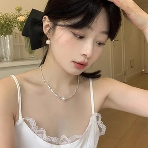 Elegant pearl jewelry set with a glossy round pendant necklace and matching stud earrings