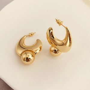 Polished gold thick C-shaped hoop earrings with a sleek ball drop charm in a modern design