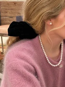 Franse vintage parelketting en oorbellen set getoond op een model in een warme omgeving