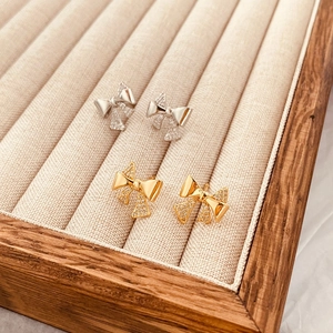 Exquisite bow stud earrings with micro-paved cubic zirconia in gold and silver finish