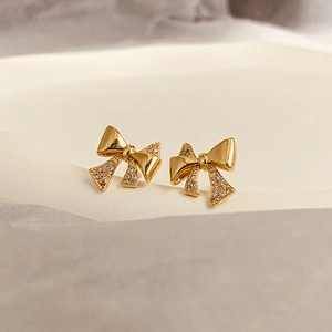 Detail of bow earrings featuring micro-pave cubic zirconia and polished gold plating