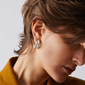 Minimalist silver C-shape layered stud earrings with polished mirror finish on model