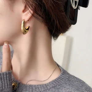 Polished 18k gold plated chunky horn earrings with elegant hollow curved design on model