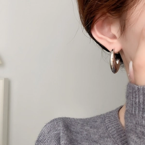 Minimalist chunky silver hoop earrings with high-polish finish shown on a female model