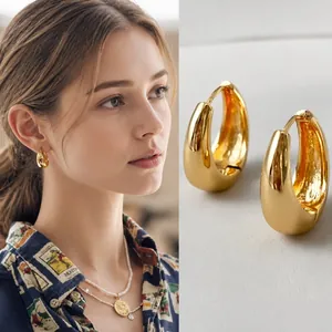 Detailweergave van gepolijste gouden oorringen met een spiegelgladde afwerking voor dames