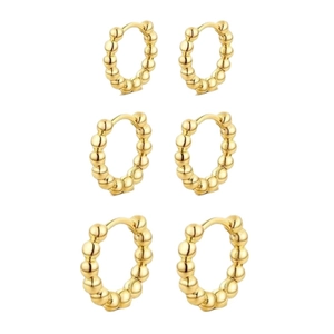Trois paires de boucles d'oreilles créoles dorées à billes disposées sur fond blanc