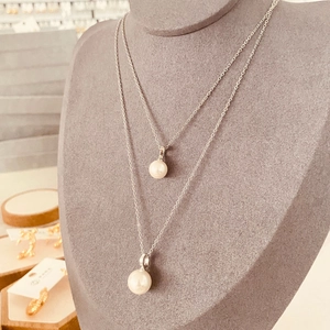 Ensemble de colliers avec pendentifs en perles d'acier sur support en velours