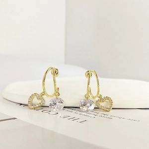Macro shot of gold-plated double-hoop earrings featuring pavé heart and round zircon drops