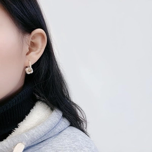 Gros plan de boucles d'oreilles fleur en perles et zircons plaqués or sur le mannequin