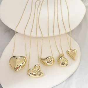 Ensemble de colliers dorés en acier inoxydable avec pendentifs cœur et goutte sur céramique