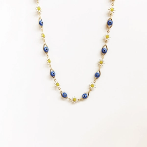 Nahaufnahme der 14K vergoldeten Kette mit Gänseblümchen und blauen Evil Eye Anhängern