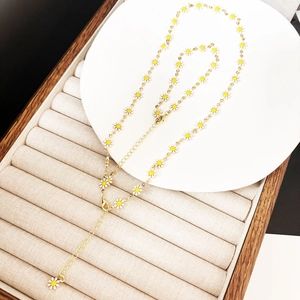 Detail der 14K vergoldeten Halskette mit weißen und gelben Emaille-Gänseblümchen-Blüten