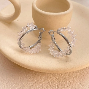 Chic silver C-shape earrings with shimmering cubic zirconia crystals on a ceramic tray