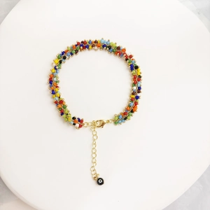 Close-up of colorful beaded bracelet with 14K gold-plated clasp and evil eye charm detail