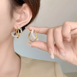 Detailed view of gold hoop earrings featuring sparkling white zircon bead clusters
