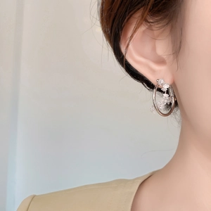 Macro view of geometric hoop earring with sparkling clear cubic zirconia flower beads