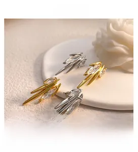 Detail of spiked stud earrings in gold and silver finish with marquise cubic zirconia