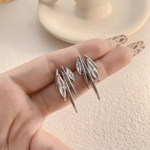 Detail of silver stud earrings with marquise-cut cubic zirconia and metallic spikes