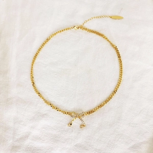 Collier doré avec pendentif nœud serti de cristaux et chaîne cubaine élégante pour femme