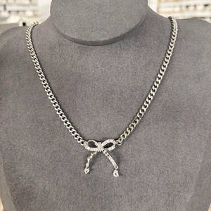 Collier maille gourmette avec pendentif nœud en diamants et breloques gouttes d'eau