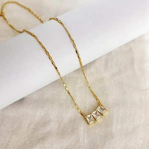 Gros plan du collier chaîne bambou plaqué or avec trois pierres zircon brillantes