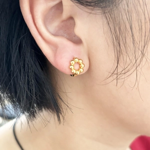 Dettaglio orecchino a cerchio con perline placcato oro 18K indossato per riferimento