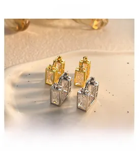 Macro view of geometric gold and silver plated earrings with rectangular zircon stones