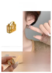 Detail of square-cut zircon earrings with 18K gold plating and hollow metal frame