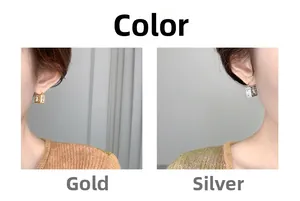 Detail of square zircon stud earrings shown in gold and silver plating on model