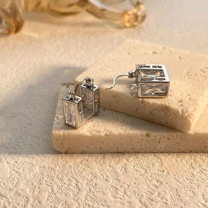 Elegant silver square zircon earrings with emerald-cut crystals on textured stone base