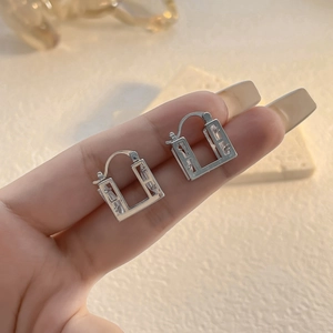 Macro shot of silver-plated earrings featuring baguette-cut cubic zirconia stones