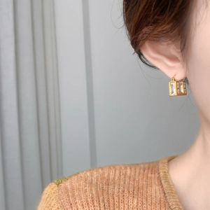 Detailed view of square cubic zirconia drop earrings with 18k gold plating finish
