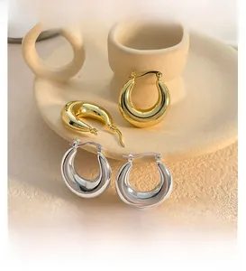 Macro detail of high-polish geometric thick hoop earrings with spring closure