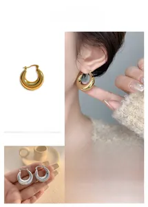 Detail view of crescent hoop earrings in polished gold and silver finishes