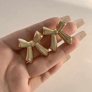 Minimalist gold bow-knot stud earrings featuring a polished mirror finish for women