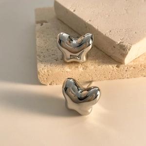 Detailed view of silver butterfly stud earrings with a liquid metal texture on stone