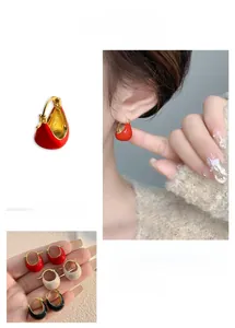 Détail de boucles d'oreilles en émail en forme de U en rouge, blanc et noir dorées 18K