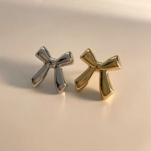 Minimalist metallic bow stud earrings in silver and gold finish with soft shadows