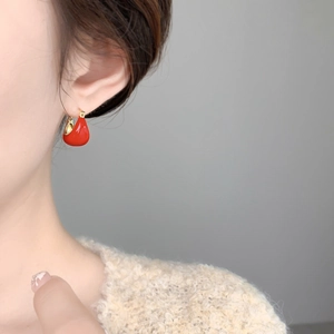 Vue détaillée d'une boucle d'oreille en émail rouge en forme de U avec dorure 18K