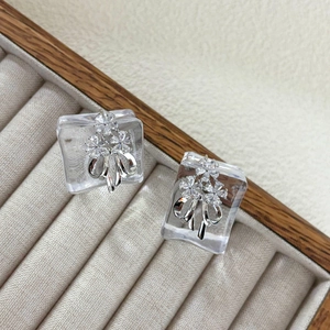 Elegant silver bow stud earrings featuring sparkling cubic zirconia in floral patterns