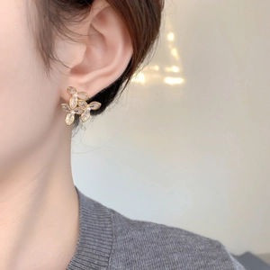 Détail de la boucle d'oreille fleur avec zircon marquise et perle sur un mannequin